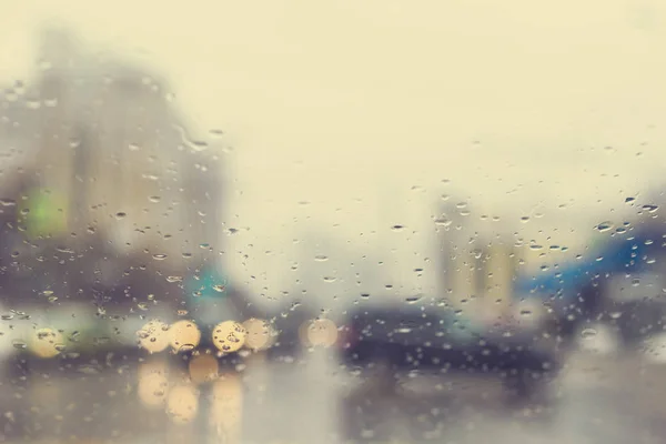交差点と横断歩道で雨滴を持つ車のフロントガラスを通してぼやけた視界 — ストック写真
