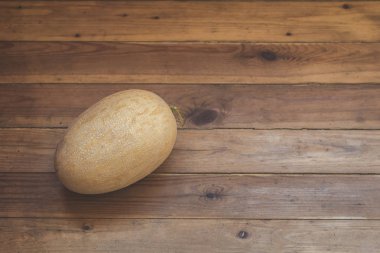 Ahşap bir terasın zemininde kocaman sarı kavun