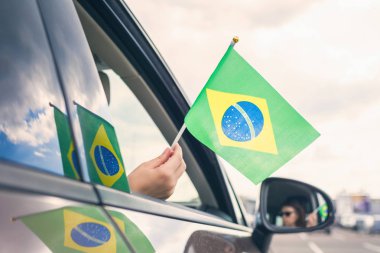 Açık araba penceresinden Brezilya bayrağı tutan kadın ya da kız. Kavram
