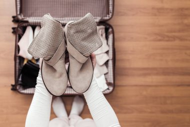 Yeni bir yolculuk için bir bavul (bavul) bir bot ambalaj kadın elleri üst görünümü. 