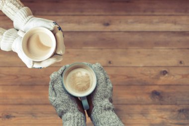 Erkek ve dişinin elleri ve tahta masa nın arka planında bir fincan kahve. Kış konsepti