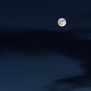 Parlak yıldızlı gece gökyüzünde kocaman bir dolunay.