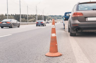 Yoldaki trafik konilerinin dikkatine. Seçici odaklanma. Çekici yolda bozuk bir arabayı çekiyor.