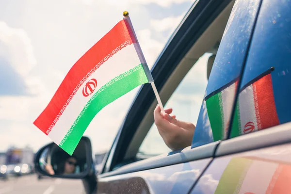 Woman or Girl Holding iranian Flag from the open car window