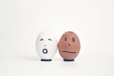 İnsan kafası şeklinde iki kırık yumurta (beyaz ve siyah) birbirlerine şikayet. Kavram. 