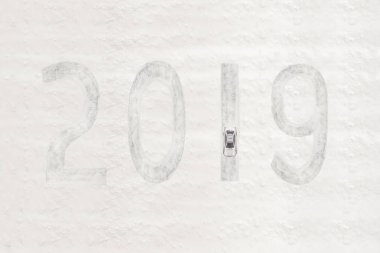 Yolda hareket eden karlı otomobilin havadan görünümü ve yeni yıl ve noel için kar 2019 çizer. Kavram