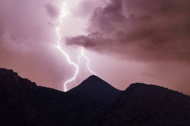 Dağlarda gece bulutlu gökyüzüne yıldırım düştü