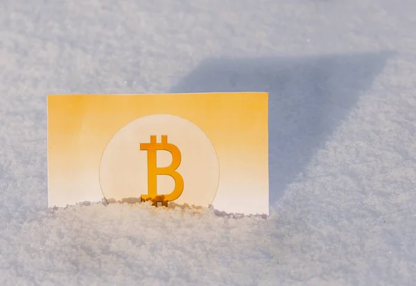 Paper gold money bitcoin in the snow in winter. Frozen account. Bankruptcy
