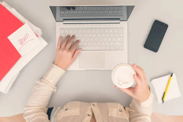 사무실에서 노트북을 작업하는 비즈니스 여성은 컵에서 커피를 마십니다 — 스톡 사진