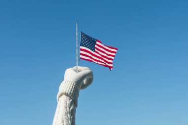 Kış arka planda Amerikan bayrağı olan örme eldivenli kadın eli. El ve iyi sembolü Abd zafer ve özgürlük. Kavram
