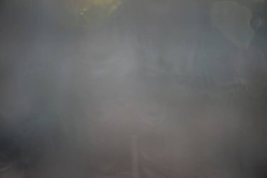 Karanlık bulutlu gökyüzü ve şehir arka plan üzerinde pencere gözlük yüzeyinde yağmur damlaları. Bulanık