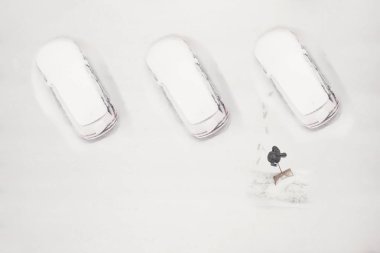 The owner of the car cleans the snow-covered parking space during the snow season. Winter time clipart