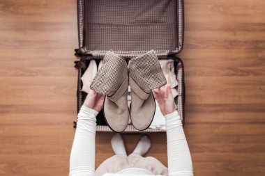 Yeni bir yolculuk için bir bavul (bavul) bir bot ambalaj kadın elleri üst görünümü. 