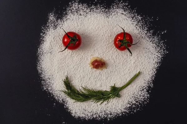 Foto Von Lächelnden Gesichtern Aus Tomatenpetersilienmehl Auf Schwarzem Hintergrund — Stockfoto