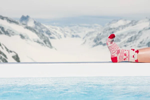 Frauenfüße Weihnachtssocken Pool Vor Dem Hintergrund Der Schweizer Alpen Winterkonzept — Stockfoto