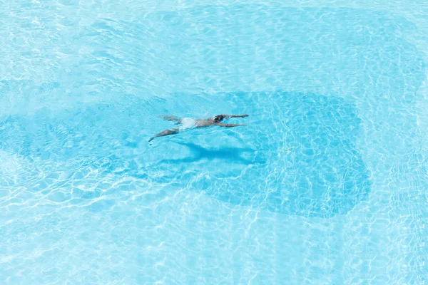 在游泳池与透明蓝水的男孩鸟瞰图 在运动中 — 图库照片