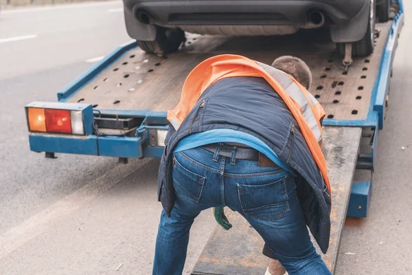 高速道路上で壊れた車を牽引する労働者とレッカー車 — ストック写真