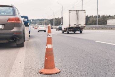 Yoldaki trafik konilerinin dikkatine. Seçici odaklanma. Çekici yolda bozuk bir arabayı çekiyor.