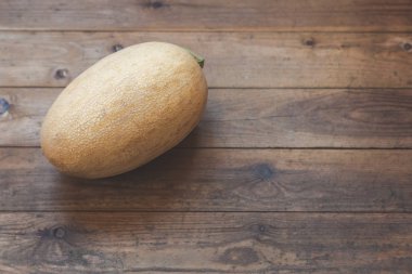 Ahşap bir terasın zemininde kocaman sarı kavun