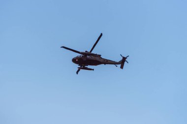 Helikopter mavi gökyüzüne karşı uçuyor. Alt görünüm