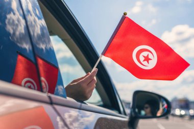 Açık araba penceresinden Tunus Bayrağı Tutan Kadın veya Kız