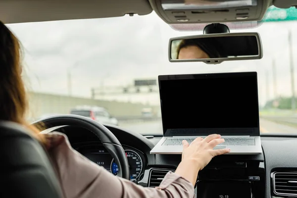 高速道路で車を運転しながら ラップトップを使用して働くビジネスウーマン テキスト用のスペース — ストック写真