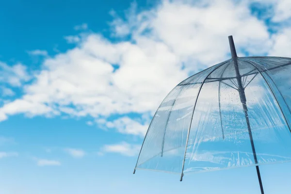 transparent umbrella on a rainy autumn day on the cloudy sky background
