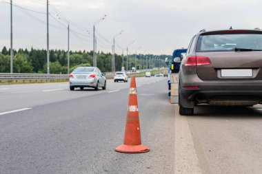 Yoldaki trafik konilerinin dikkatine. Seçici odaklanma. Çekici yolda bozuk bir arabayı çekiyor.
