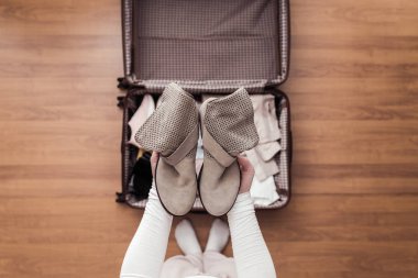 Yeni bir yolculuk için bir bavul (bavul) bir bot ambalaj kadın elleri üst görünümü. 