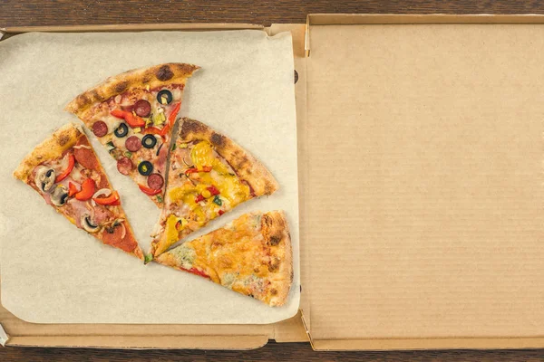 four different pieces of pizza in the open delivery box. space for text