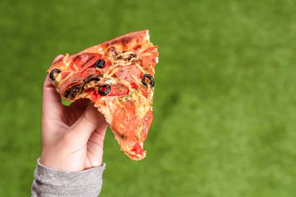 Una Rebanada Pizza Manos Femeninas Almuerzo Hierba Verde — Foto de Stock