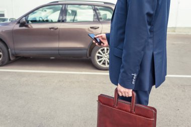 Müşteri kapıyı açmak için cep telefonunu tutuyor. Araba paylaşım servisi veya kiralama kavramı. 