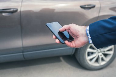 Müşteri kapıyı açmak için cep telefonunu tutuyor. Araba paylaşım servisi veya kiralama kavramı. 