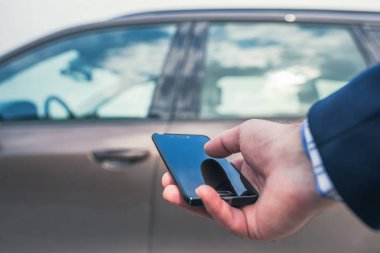 Müşteri kapıyı açmak için cep telefonunu tutuyor. Araba paylaşım servisi veya kiralama kavramı. 