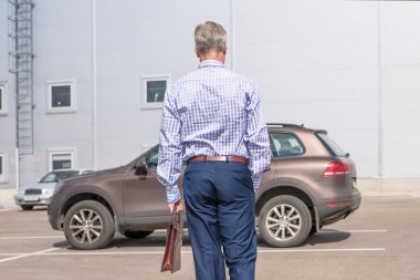 Şehirde arabanın yanında duran adam. 