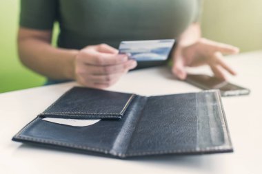 Kafe masasında elinde dosya ve fatura olan kadın eli resmi var. Restoran ziyaretçisi kredi kartıyla ödemeye hazır.