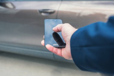 Müşteri kapıyı açmak için cep telefonunu tutuyor. Araba paylaşım servisi veya kiralama kavramı. 