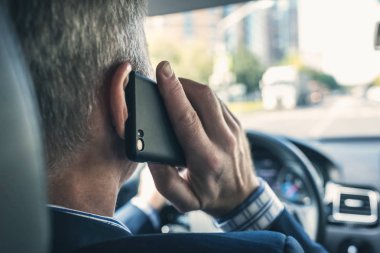 Araba sürüş sırasında akıllı telefon kullanan adam