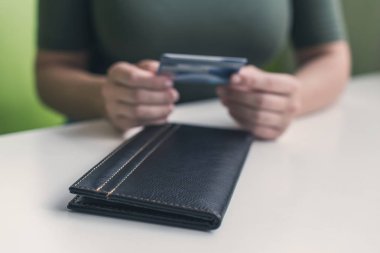 Kafe masasında elinde dosya ve fatura olan kadın eli resmi var. Restoran ziyaretçisi kredi kartıyla ödemeye hazır.