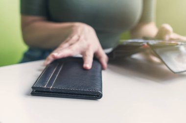 Kafe masasında elinde dosya ve fatura olan kadın eli resmi var. Restoran ziyaretçisi kredi kartıyla ödemeye hazır.