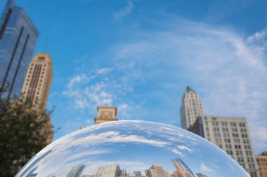 Şehir merkezindeki gökdelenler Chicago, Illinois 'deki Millennium Park' taki Fasulye heykelinin ayna yüzeyine yansıdı..