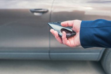 Müşteri kapıyı açmak için cep telefonunu tutuyor. Araba paylaşım servisi veya kiralama kavramı. 