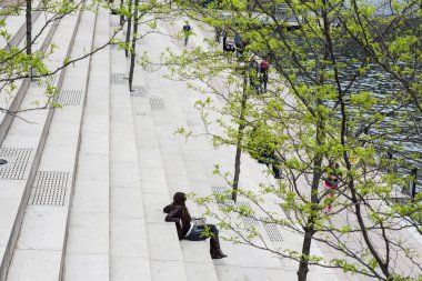 İnsanlar Chicago parkının merdivenlerinde dinleniyor. 