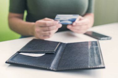 Kafe masasında elinde dosya ve fatura olan kadın eli resmi var. Restoran ziyaretçisi kredi kartıyla ödemeye hazır.