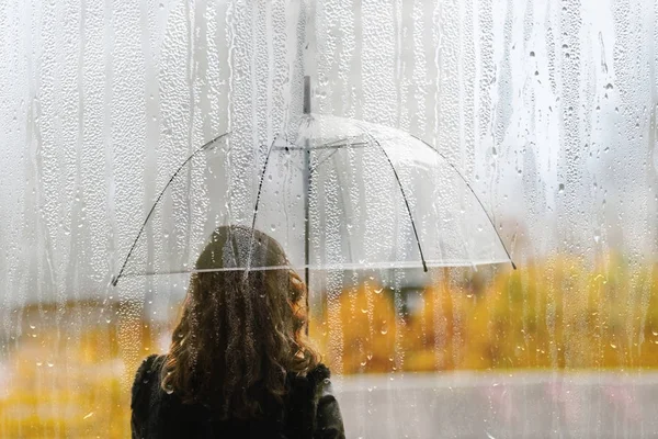 雨の滴と濡れた窓から透明な傘と女性のシルエット — ストック写真