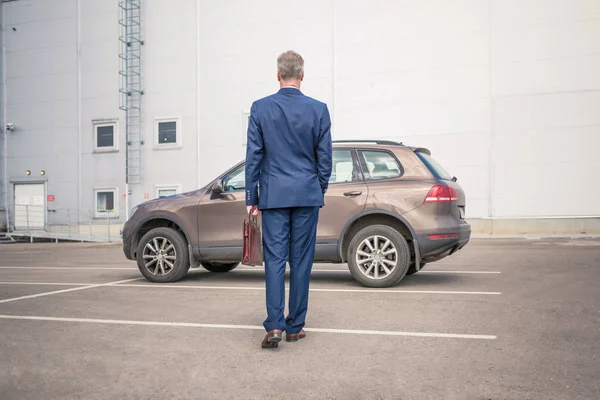 Şehirde arabanın yanında duran adam. 