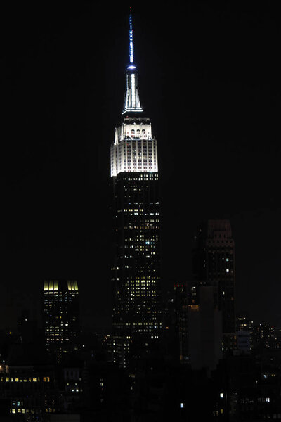 Empire State Building with New York City Manhattan skyline and skyscrapers at night.