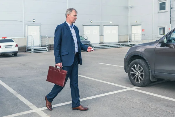 Şehirde arabanın yanında duran adam. 