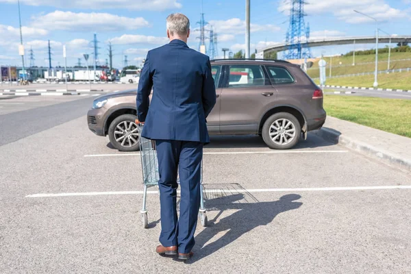 İş adamı alışveriş sonrası kediye doğru yürüyor. 