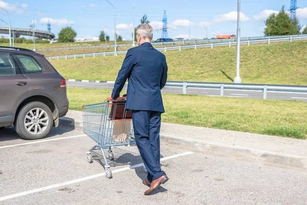 İş adamı alışveriş sonrası kediye doğru yürüyor. 
